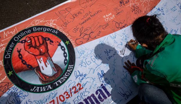 Perwakilan pengemudi ojek daring yang tergabung dalam Driver Online Bergerak Jawa Tengah secara simbolis menandatangani tuntutan aksi damai dalam unjuk rasa di depan kompleks Kantor Gubernur Jawa Tengah, Semarang, Jawa Tengah, Senin (7/3/2022). Dalam aksi tersebut mereka mengajukan beberapa tuntutan kepada Pemprov Jateng diantaranya yaitu perlindungan hukum bagi pengemudi daring selaku mitra terkait kesejahteraan, keamanan, dan kenyamanan, pelibatan mitra dalam kebijakan dengan sistem aplikasi, kontrol kuota ojek daring di Jawa Tengah, kenaikan tarif minimal jasa pengantaran penumpang dan barang, serta adanya jaminan asuransi tenaga kerja dari aplikator. ANTARA FOTO/Aji Styawan/rwa