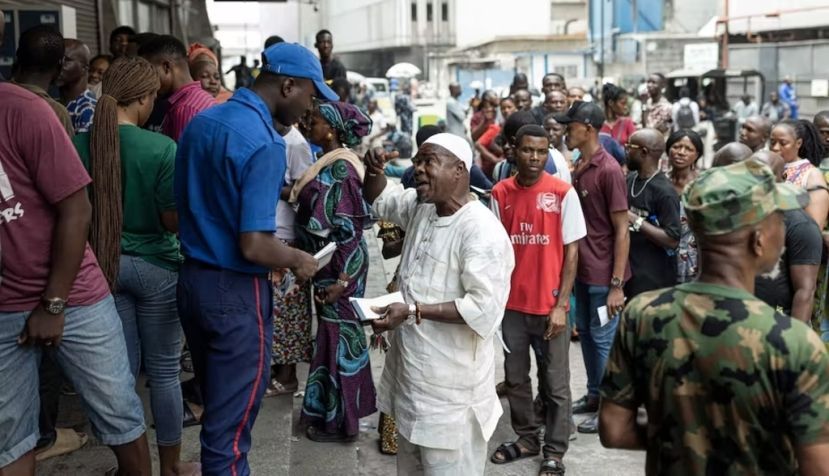 People queue outside a bank in Lagos on February 22, 2023. Nigeria was hit with a scarcity of cash after the central bank began to swap old Naira notes for new bills. Patrick Meinhardt / AFP