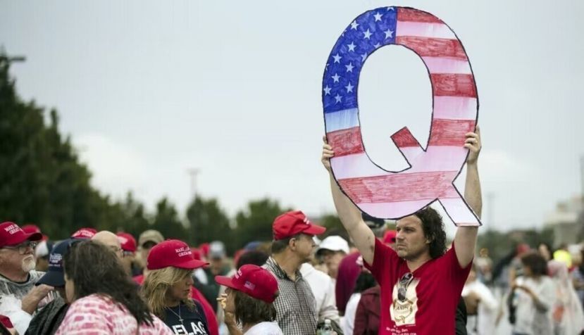 A protester holds a Q sign as he waits to enter a campaign rally with then-President Donald Trump in Wilkes-Barre, Pa., in August 2018. AP Photo/Matt Rourke