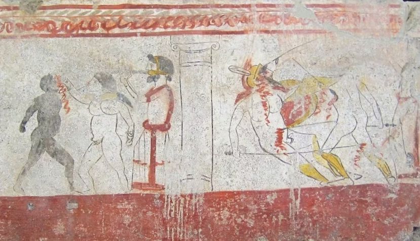 Juegos de gladiadores (a la derecha un combate armado, y a la izquierda un combate de boxeo entre un blanco y un negro al son del aulós) en honor de un difunto. Fresco de tumba lucana en el Museo Arqueológico Nacional de Paestum. Velvet/Wikimedia Commons, CC BY-SA