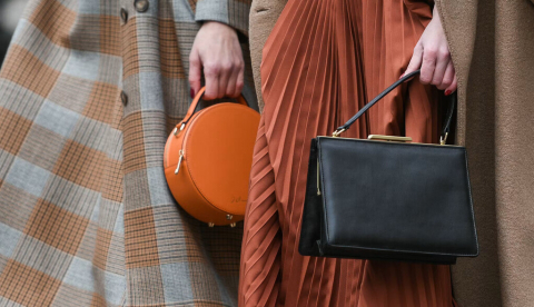  Dos mujeres a los que se les ve solo de mitad de cuerpo para abajo pasean con ropas y bolsos de moda. Creative Lab/Shutterstock