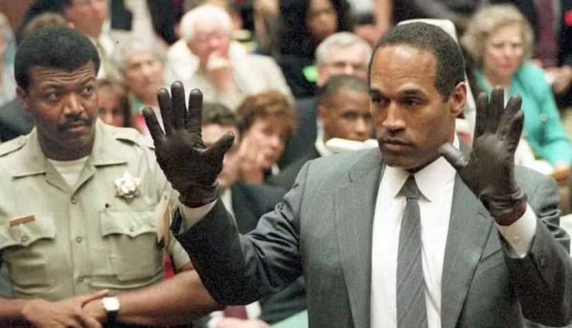 O.J. Simpson montre au jury une paire de gants similaires à ceux trouvés sur les lieux du crime, lors de son procès à Los Angeles en 1995. POO/AFP via Getty Images