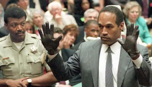 O.J. Simpson montre au jury une paire de gants similaires à ceux trouvés sur les lieux du crime, lors de son procès à Los Angeles en 1995. POO/AFP via Getty Images