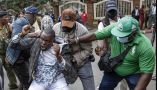  A man is grabbed by his clothes by three men dressed in jeans, T-shirts and jackets Plainclothes Kenyan police officers arrest an activist in Nairobi during protests in September 2024. Simon Maina/AFP via Getty Images