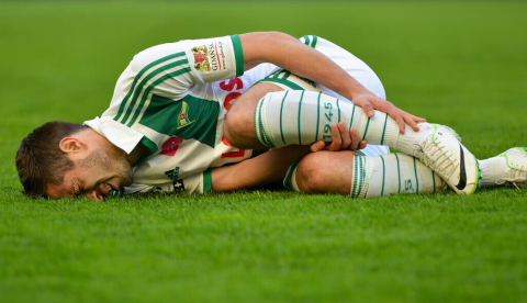 El futbolista Maciej Makuszewski se duele de una lesión durante un partido de la liga polaca de 2014. Shutterstock / Dziurek