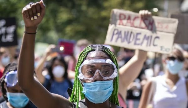 A woman raises her fist during a 2020 Black Lives Matter protest in Queens, New York. Ira L. Black/Corbis via Getty Images