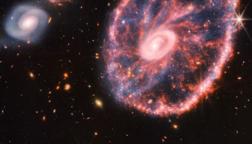 Imagen de la Rueda de Carro y sus galaxias compañeras es una composición de la Cámara del Infrarrojo Cercano (NIRCam) y del Instrumento del Infrarrojo Medio (MIRI) de Webb. Esta galaxia se formó como resultado de una colisión a gran velocidad que ocurrió hace unos 400 millones de años. NASA, ESA, CSA, STScI, Webb ERO Production Team