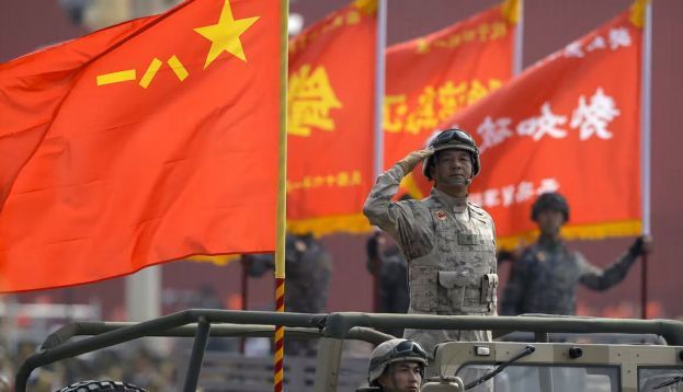 A military officer salutes during a parade to commemorate the anniversary of the founding of Communist China in Beijing. Mark Schiefelbein/AP