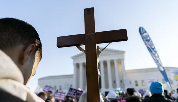 Anti-abortion protesters holding a cross demonstrate in front of the Supreme Court Building in December 2021, in Washington. AP Photo/Jose Luis Magana