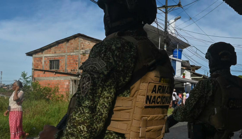 Miembros de la Armada colombiana montan guardia mientras los lugareños pasan en Buenaventura, Colombia. Joaquín Sarmiento/AFP vía Getty Images