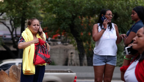  Personas hablando por el móvil en una calle. Fotografía tomada en una calle de Caracas el pasado 26 de junio. ttanni/Shutterstock