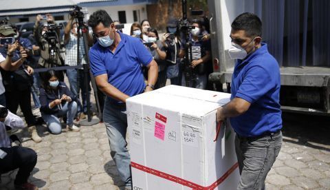 Dos hombres bajan de un camión una caja que contiene dosis de las vacunas contra la covid-19 hoy, en el Centro Nacional de Biológicos (CENABI), en Soyapango (El Salvador). 