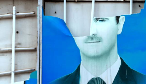 End of a half-century of family rule. A damaged portrait of Syrian President Bashar al-Assad hangs in the Syrian city of Qamishli. Delil Souleiman/AFP via Getty Images