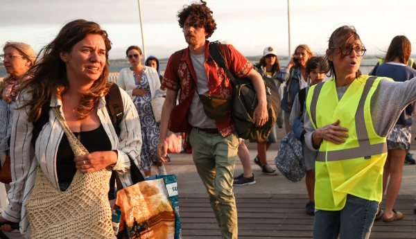 Opération d’évacuation de touristes arrivant à Arcachon guidés par une bénévole le 24 juillet 2026. Romain Perrocheau / AFP