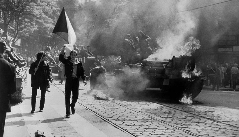 Jóvenes checoslovacos llevan la Bandera de Checoslovaquia frente a un tanque soviético en llamas en Praga durante la invasión de 1968 en una imagen del fondo fotográfico de la CIA. / Wikipedia