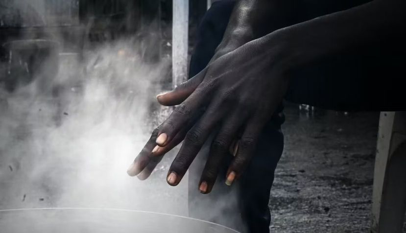 Un jeune soudanais se réchauffe les mains dans un camp de migrants à Ouistreham, dans le nord de la France. Photo prise pour un reportage de Mathieu Clavel. Lou Benoist/AFP