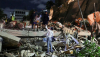  Varias personas sobre los escombros de un edificio por la noche Consecuencias de los dos terremotos del 24 de junio en Caracas. Mytaj1/Shutterstock
