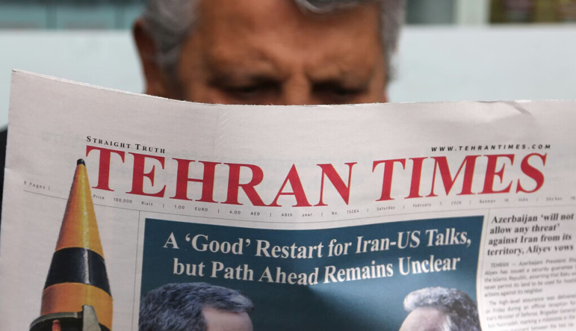 Un hombre sentado leyendo un periódico llamado «Tehran Times». El 7 de febrero de 2026, los periódicos iraníes publicaron titulares sobre la reanudación de las negociaciones nucleares entre Irán y Estados Unidos, tras su suspensión a raíz de los ataques israelíes y estadounidenses contra Irán en junio de 2025. Fatemeh Bahrami/Anadolu vía Getty Images