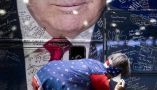 A person signs a bus wrapped with an image of former President Donald Trump during the Conservative Political Action Conference on Feb. 22, 2024. Brendan Smialowski/AFP via Getty Images