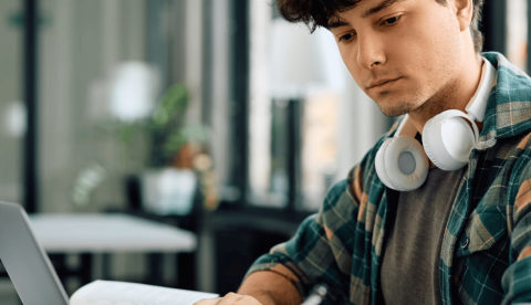  Un joven con un cuaderno y un portátil. Drazen Zigic/Shutterstock