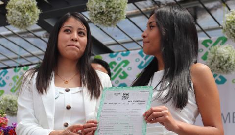 CIUDAD DE MÉXICO (MÉXICO), 14/03/2020.- Aidé (i) y Carmen (d) participaron este sábado en una unión matrimonial masiva en la explanada del Registro Civil de Ciudad de México (México). El Gobierno de la capital mexicana celebró este sábado los 10 años del reconocimiento legal del matrimonio igualitario con una boda colectiva en la que participaron 140 parejas del mismo sexo en la explanada del Registro Civil. En el festejo también se conmemoró el quinto aniversario de la ley de identidad de género, que permite a las personas trans rectificar este dato en sus documentos oficiales, como lo hicieron 31 personas en esta jornada de Matrimonio Igualitario e Identidad de Género, organizado por Ciudad de México. EFE/ José Pazos