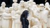 A woman wears a face mask as she walks by the sculpture ‘The Illuminated Crowd’ on a street in Montréal. Vulnerable people may benefit from measures like face masks even after the COVID-19 pandemic. THE CANADIAN PRESS/Graham Hughes
