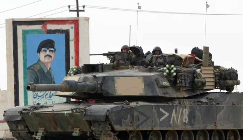 Un tanque estadounidense pasa junto a un reatrato de Saddam Hussein en marzo de 2003 en Nasiriyah, Irak. Joe Raedle/Getty Images