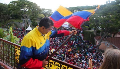 Fotografía cedida hoy por la oficina de Prensa del Palacio de Miraflores donde se observa al presidente venezolano Nicolás Maduro mientras ondea una bandera de su país frente a simpatizantes durante un acto de Gobierno, en Caracas (Venezuela). 