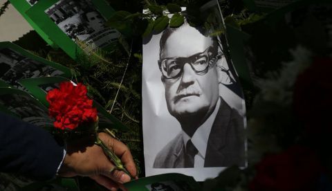 Un hombre deja una flor sobre la imagen del presidente chileno Salvador Allende.