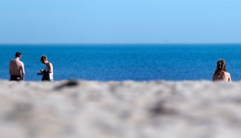 Varias personas pasean por la playa de la Malvarrosa de Valencia, este martes, con temperaturas que rozan los 30 grados. Las temperaturas máximas de la Comunitat Valenciana bajarán el miércoles de forma notable y localmente extraordinaria, más de 10 grados, para situarse en los valores normales de estas fechas, el centro del invierno. EFE/Kai Försterling