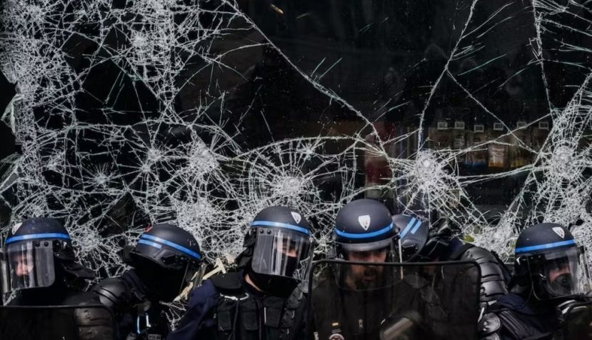 Affrontements entre forces de l'ordre à Lyon, repliés devant une vitrine cassée et manifestants lors du défilé du 1er mai. Jeff Pachoud/AFP