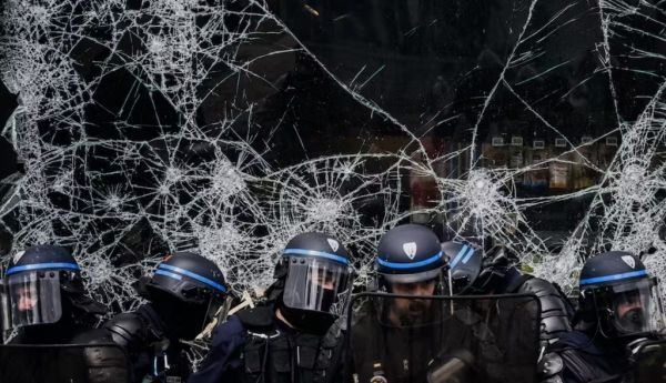 Affrontements entre forces de l'ordre à Lyon, repliés devant une vitrine cassée et manifestants lors du défilé du 1er mai. Jeff Pachoud/AFP