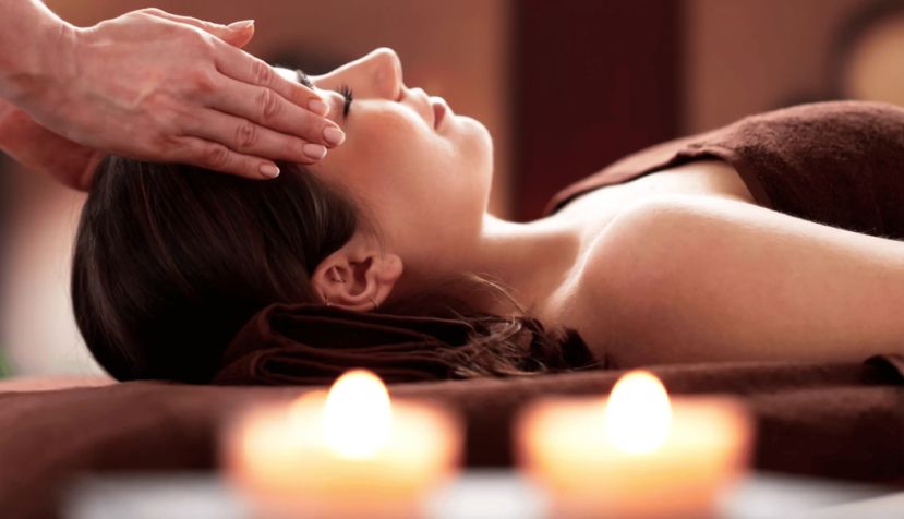  Alguien coloca las manos en las dos sienes de una mujer. El reiki se basa en canalizar algo que llaman qi (una supuesta “energía vital”, carente de respaldo científico) mediante la imposición de manos a escasos centímetros de la persona. Andrey_Popov/Shutterstock