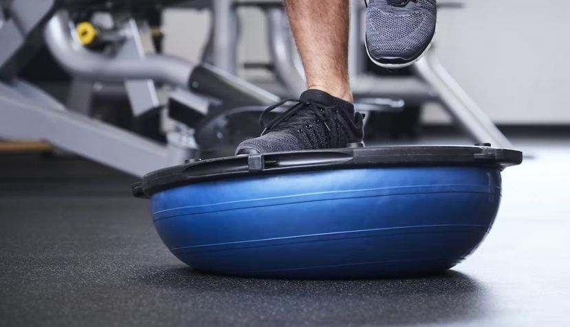 Ejercicios sobre un bosu, plataforma semiesférica con parte rígida que se utiliza para entrenar el equilibrio. Shutterstock / the stock company